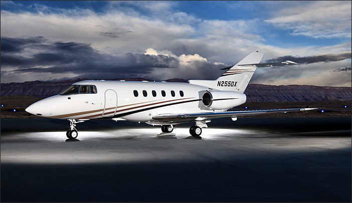 A white private jet with brown and gold stripes sits on a tarmac at dusk, with mountains and a cloudy sky in the background. The aircraft registration number N2550X is visible.