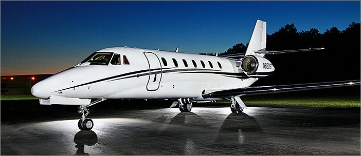 A 2006 Citation Sovereign s/n 0075 Cessna, sold by General Aviation Services, is parked on a tarmac at dusk, with external lights illuminating the aircraft.