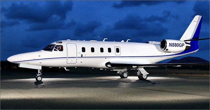 A 1997 Astra SPX, tail number N880GP, is a used Astra by General Aviation Services. This sleek white private jet with blue accents is parked on a runway at night under a cloudy sky.