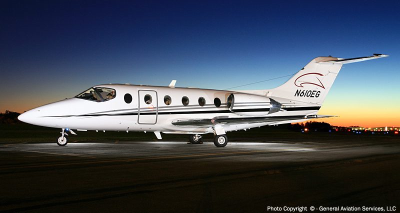 A white private jet with registration N610EG is parked on a runway at dusk with a clear sky in the background.