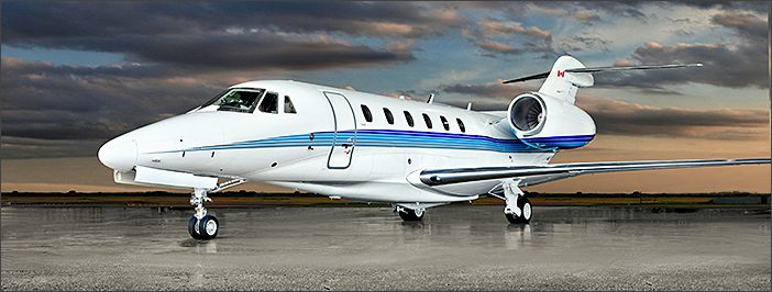 A 1999 Citation X used corporate jet with blue stripes is parked on a tarmac under a cloudy sky at sunset, showcasing the elegance of general aviation services.