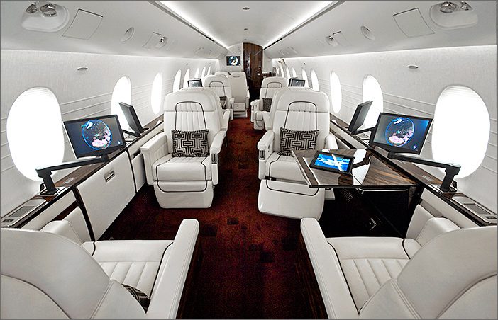 Interior of a 2002 Dornier 328310 used jet featuring white leather seats, fold-out tables, built-in screens, and windows on both sides—all in a spacious, modern layout. Explore this exceptional aircraft for sale.